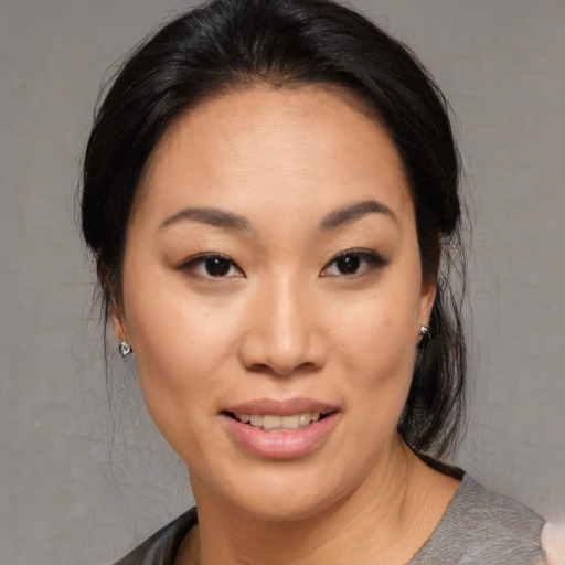 Joyful asian young-adult female with medium  brown hair and brown eyes