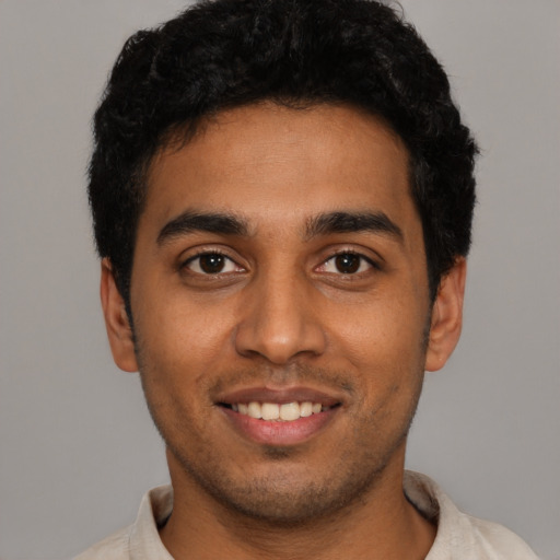 Joyful latino young-adult male with short  black hair and brown eyes