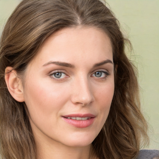 Joyful white young-adult female with long  brown hair and blue eyes