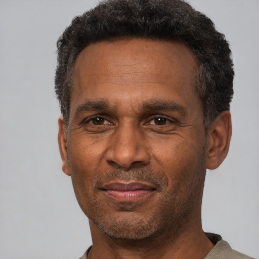 Joyful latino adult male with short  black hair and brown eyes