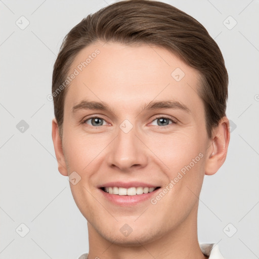 Joyful white young-adult male with short  brown hair and grey eyes