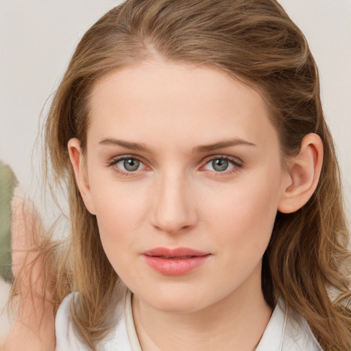 Joyful white young-adult female with long  brown hair and blue eyes