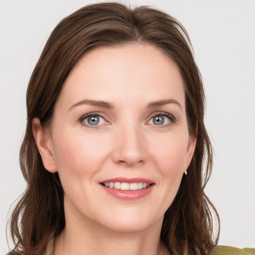 Joyful white young-adult female with medium  brown hair and grey eyes