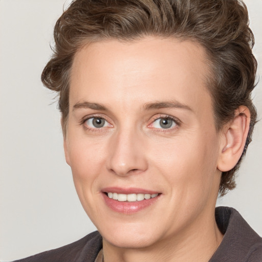 Joyful white adult female with medium  brown hair and grey eyes