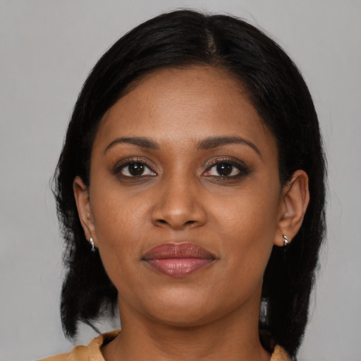 Joyful black young-adult female with medium  black hair and brown eyes