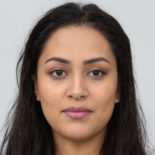 Joyful latino young-adult female with long  brown hair and brown eyes