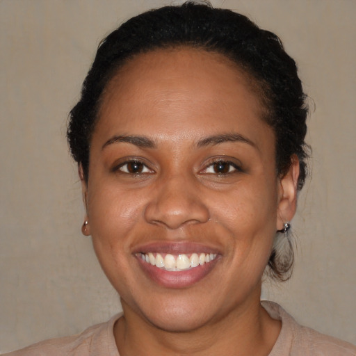 Joyful black adult female with short  brown hair and brown eyes
