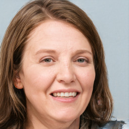 Joyful white adult female with long  brown hair and blue eyes