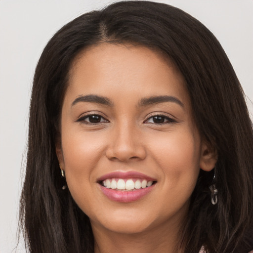 Joyful latino young-adult female with long  brown hair and brown eyes