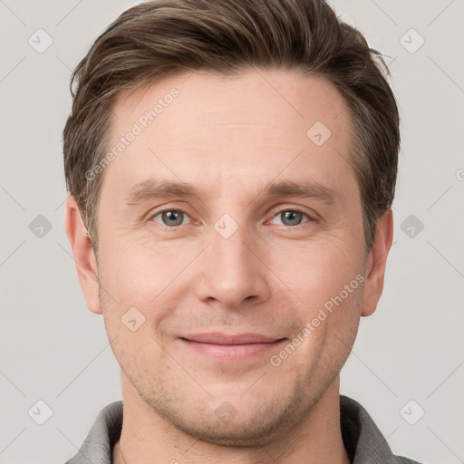 Joyful white young-adult male with short  brown hair and grey eyes