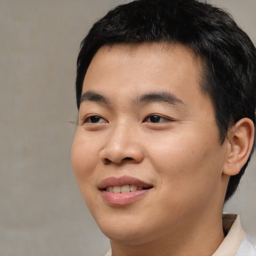 Joyful asian young-adult male with short  black hair and brown eyes