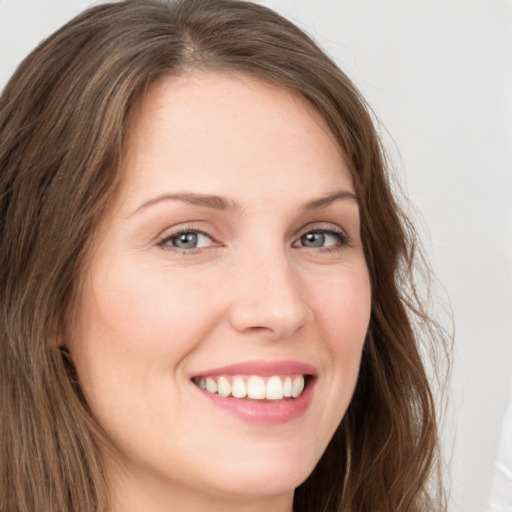 Joyful white young-adult female with long  brown hair and green eyes