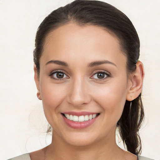 Joyful white young-adult female with long  brown hair and brown eyes