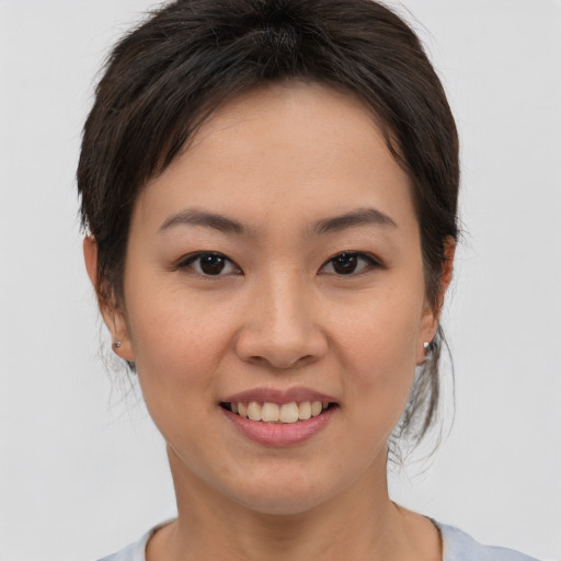 Joyful asian young-adult female with medium  brown hair and brown eyes