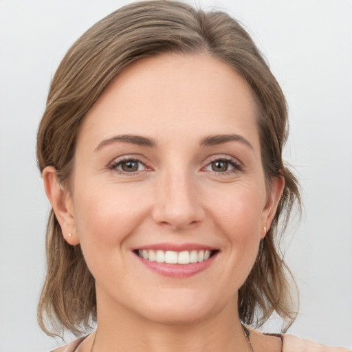 Joyful white young-adult female with medium  brown hair and grey eyes