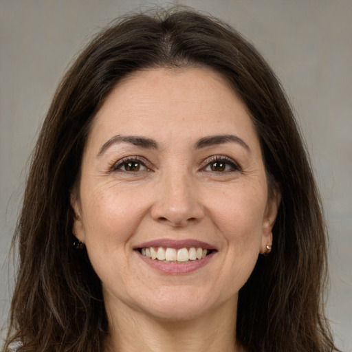 Joyful white adult female with long  brown hair and brown eyes