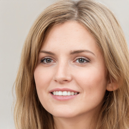 Joyful white young-adult female with long  brown hair and blue eyes