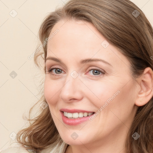 Joyful white young-adult female with long  brown hair and blue eyes