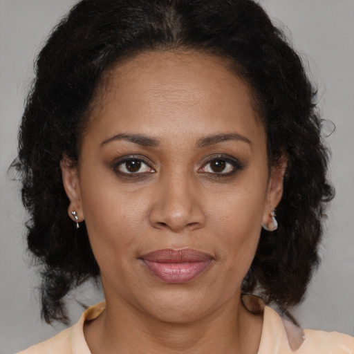 Joyful latino adult female with medium  brown hair and brown eyes