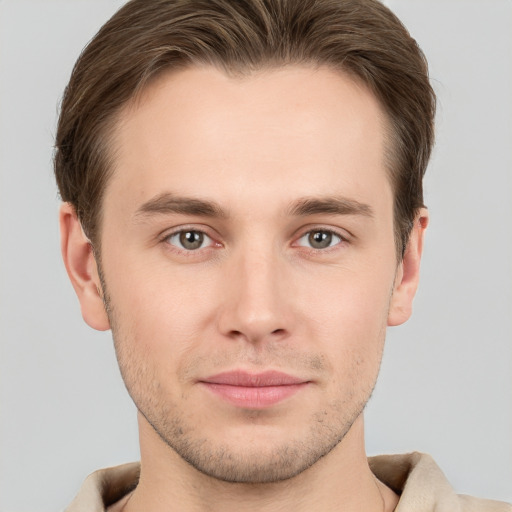 Joyful white young-adult male with short  brown hair and grey eyes