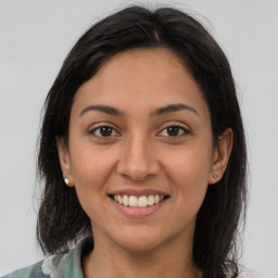 Joyful latino young-adult female with long  brown hair and brown eyes