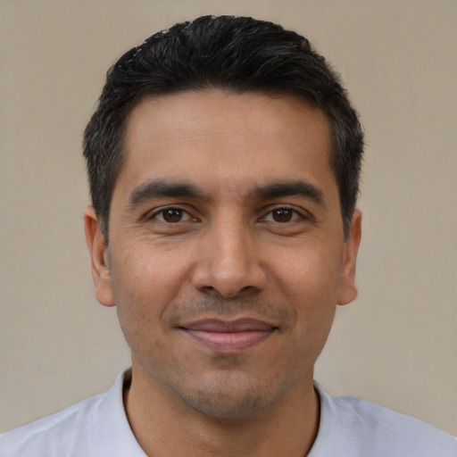 Joyful latino young-adult male with short  black hair and brown eyes