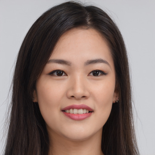 Joyful asian young-adult female with long  brown hair and brown eyes