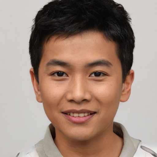 Joyful asian young-adult male with short  black hair and brown eyes