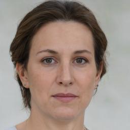 Joyful white adult female with medium  brown hair and green eyes