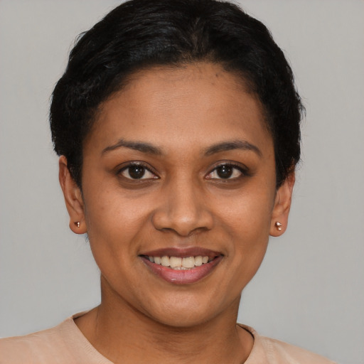 Joyful latino young-adult female with short  black hair and brown eyes