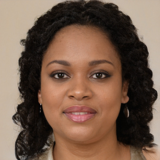 Joyful black young-adult female with long  brown hair and brown eyes