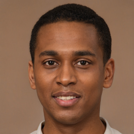 Joyful black young-adult male with short  black hair and brown eyes