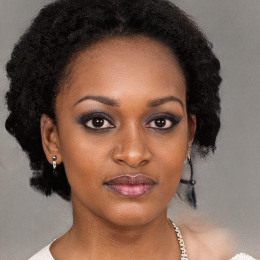 Joyful black young-adult female with long  black hair and brown eyes