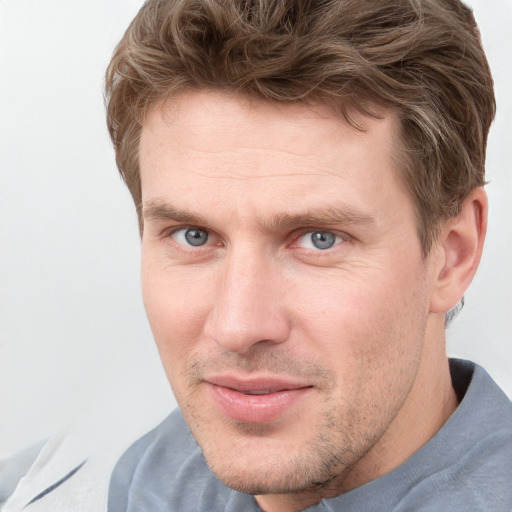 Joyful white adult male with short  brown hair and blue eyes