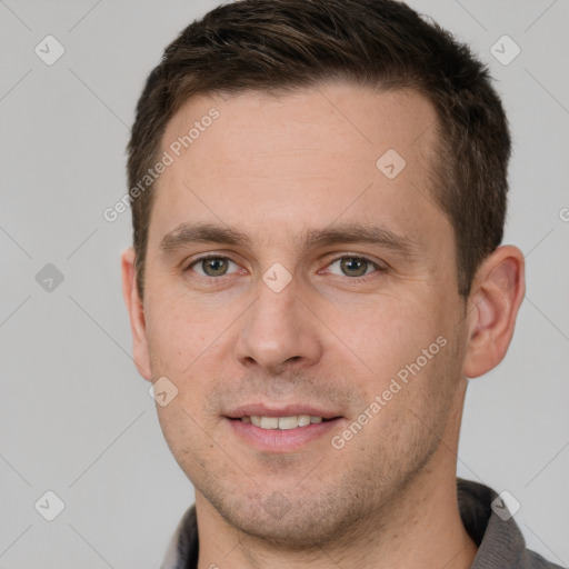 Joyful white young-adult male with short  brown hair and grey eyes