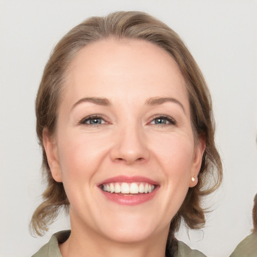 Joyful white adult female with medium  brown hair and grey eyes