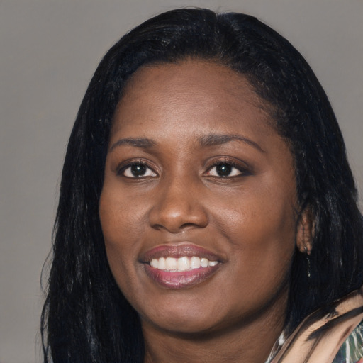 Joyful black young-adult female with long  black hair and brown eyes