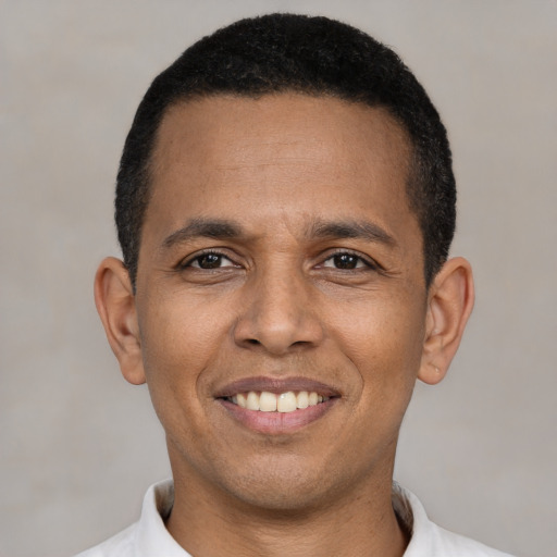 Joyful latino young-adult male with short  black hair and brown eyes
