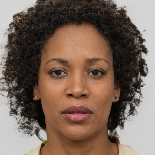 Joyful black adult female with short  brown hair and brown eyes