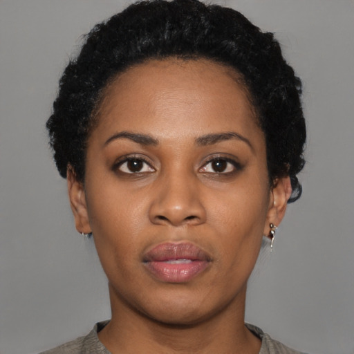 Joyful black young-adult female with short  black hair and brown eyes