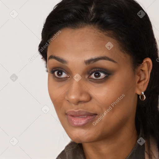 Joyful black young-adult female with long  black hair and brown eyes