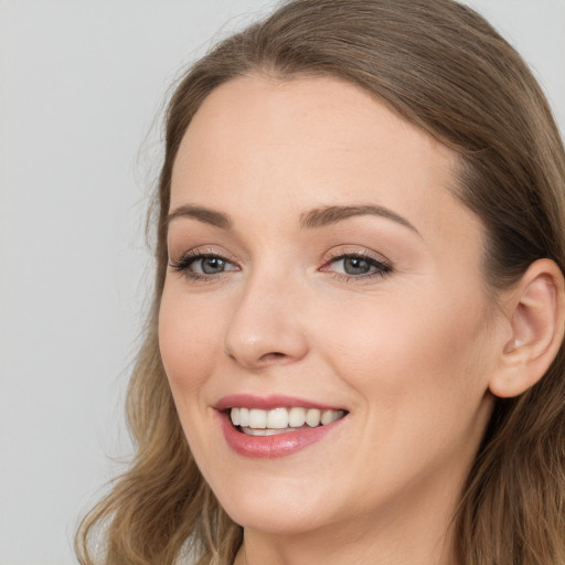 Joyful white young-adult female with long  brown hair and grey eyes