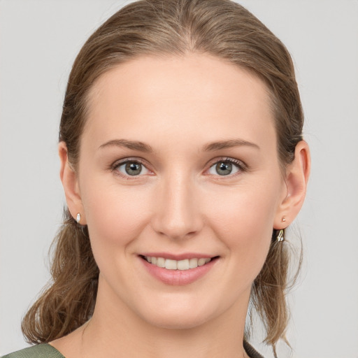 Joyful white young-adult female with medium  brown hair and grey eyes