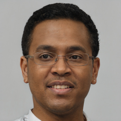 Joyful black adult male with short  brown hair and brown eyes