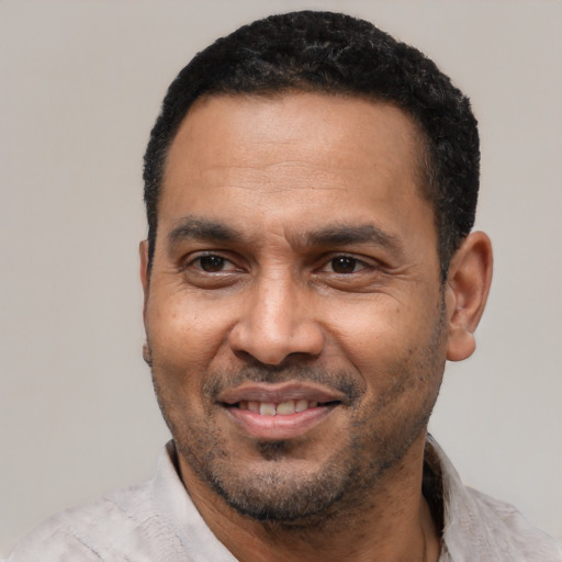 Joyful latino adult male with short  black hair and brown eyes