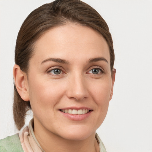 Joyful white young-adult female with medium  brown hair and grey eyes