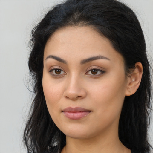 Joyful latino young-adult female with long  brown hair and brown eyes