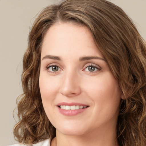 Joyful white young-adult female with long  brown hair and green eyes