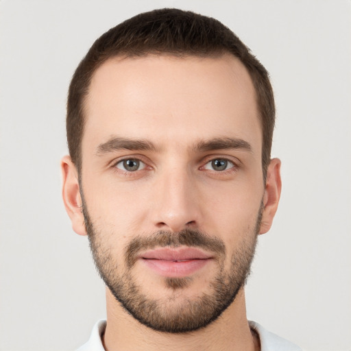 Joyful white young-adult male with short  brown hair and grey eyes