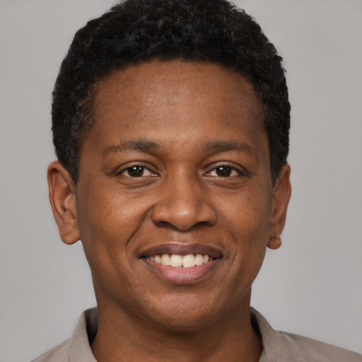 Joyful black young-adult male with short  brown hair and brown eyes